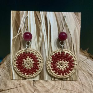 Hand-dyed hand-woven raffia earrings, hanging from hand-formed Argentium Silver hooks, with gemstones. Displayed on The Raffia Kat gift card. Dyed with avocado pit and coiled with burgundy cotton. Features dark, pink-coloured gemstones