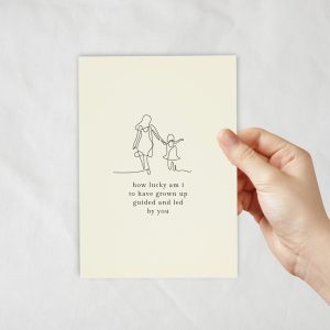 An ivory coloured card with a lineart of a mother and child walking