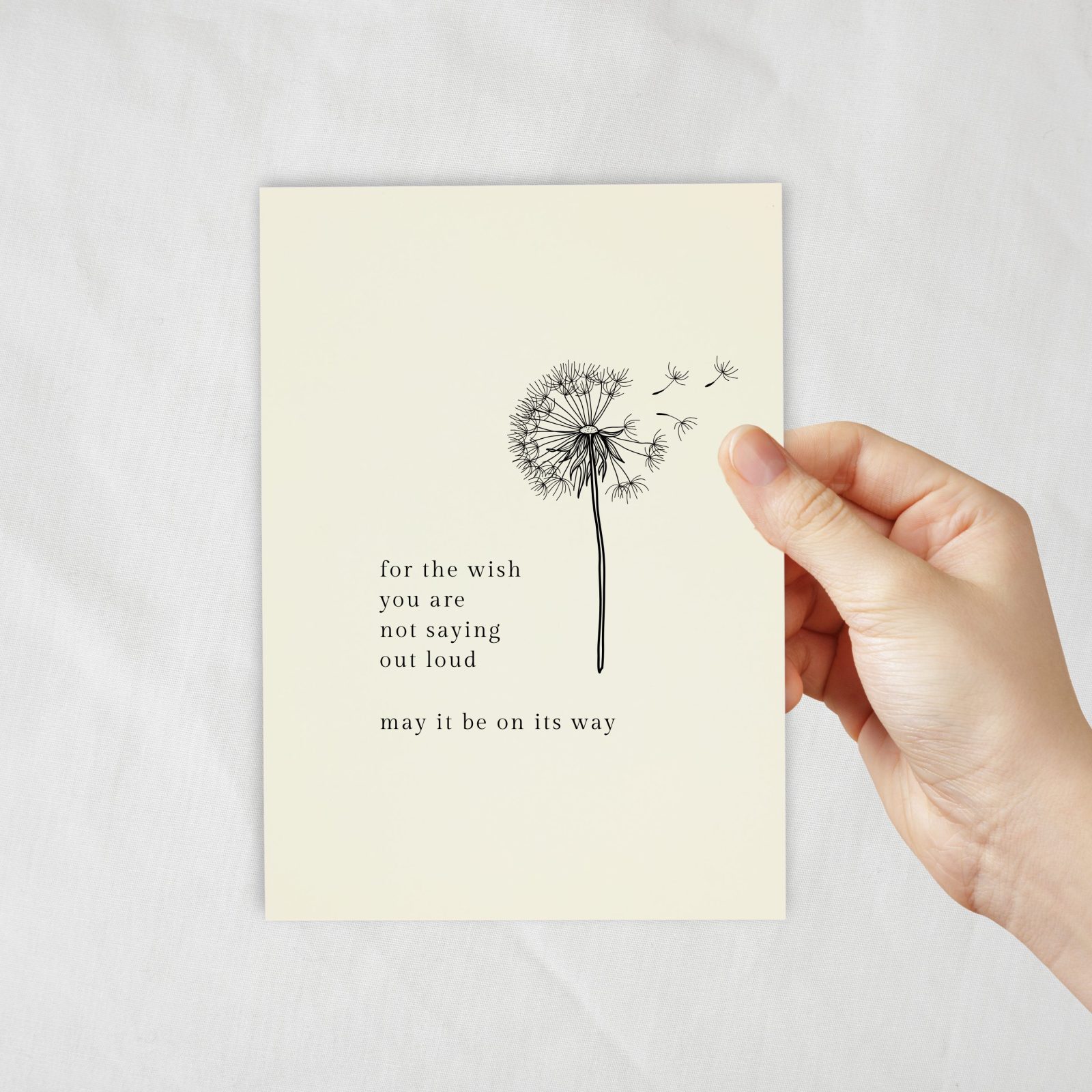 An ivory coloured card with a lineart of dandelion
