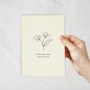 An ivory coloured card with a lineart of flowers with text underneath.