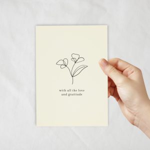 An ivory coloured card with a lineart of flowers with text underneath.